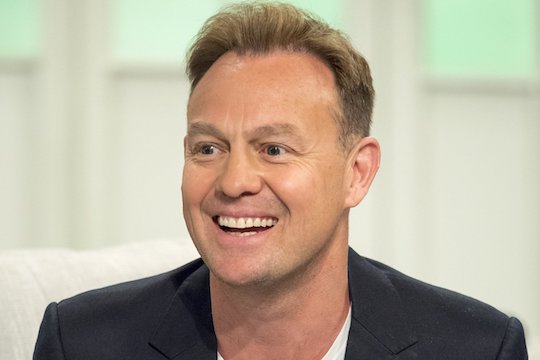 Jason Donovan smiling towards interviewer